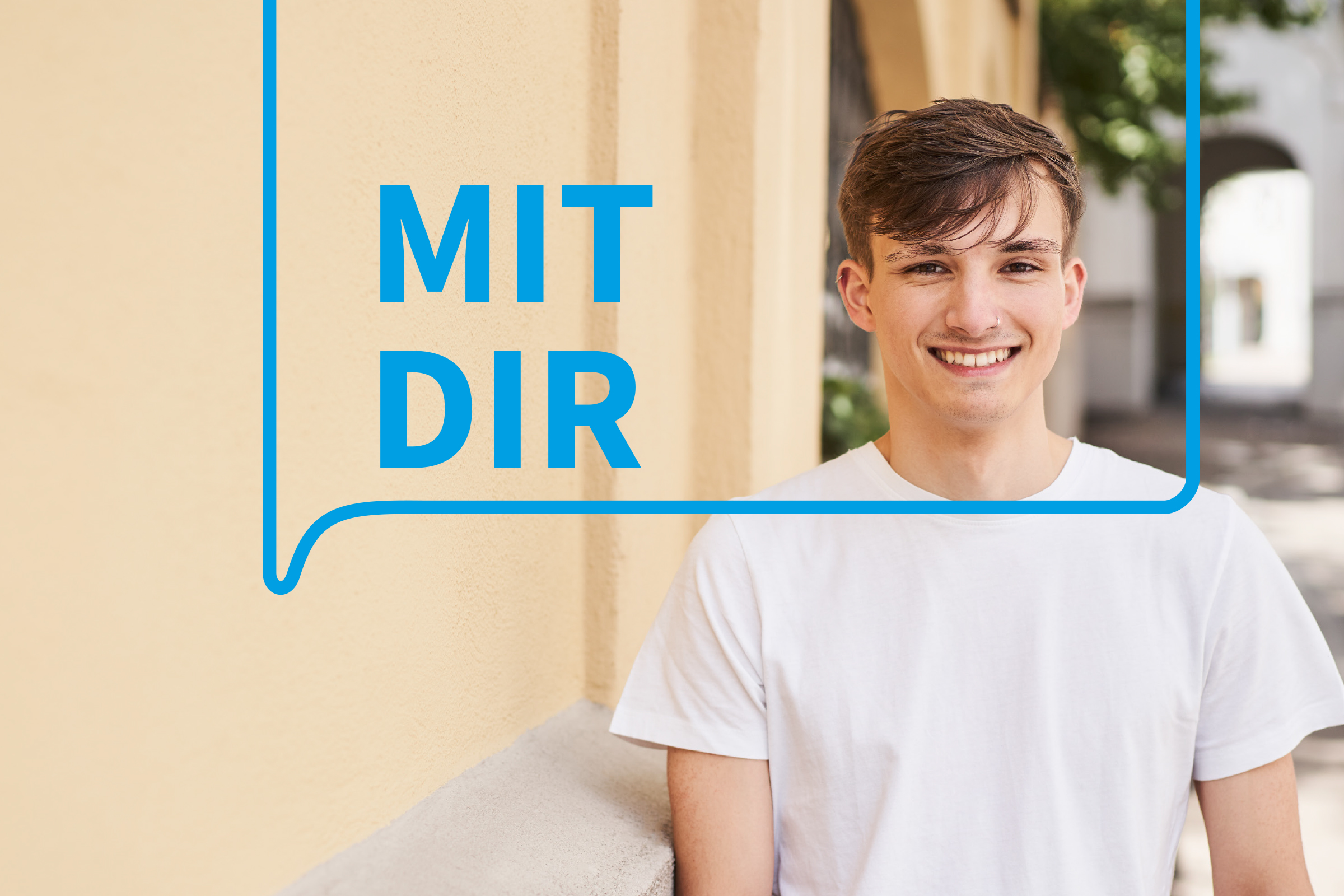 ein junger Mann lächelt, daneben der Schriftzug MIT DIR
