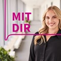 eine junge Frau lächelt, daneben der Schriftzug "MIT DIR"