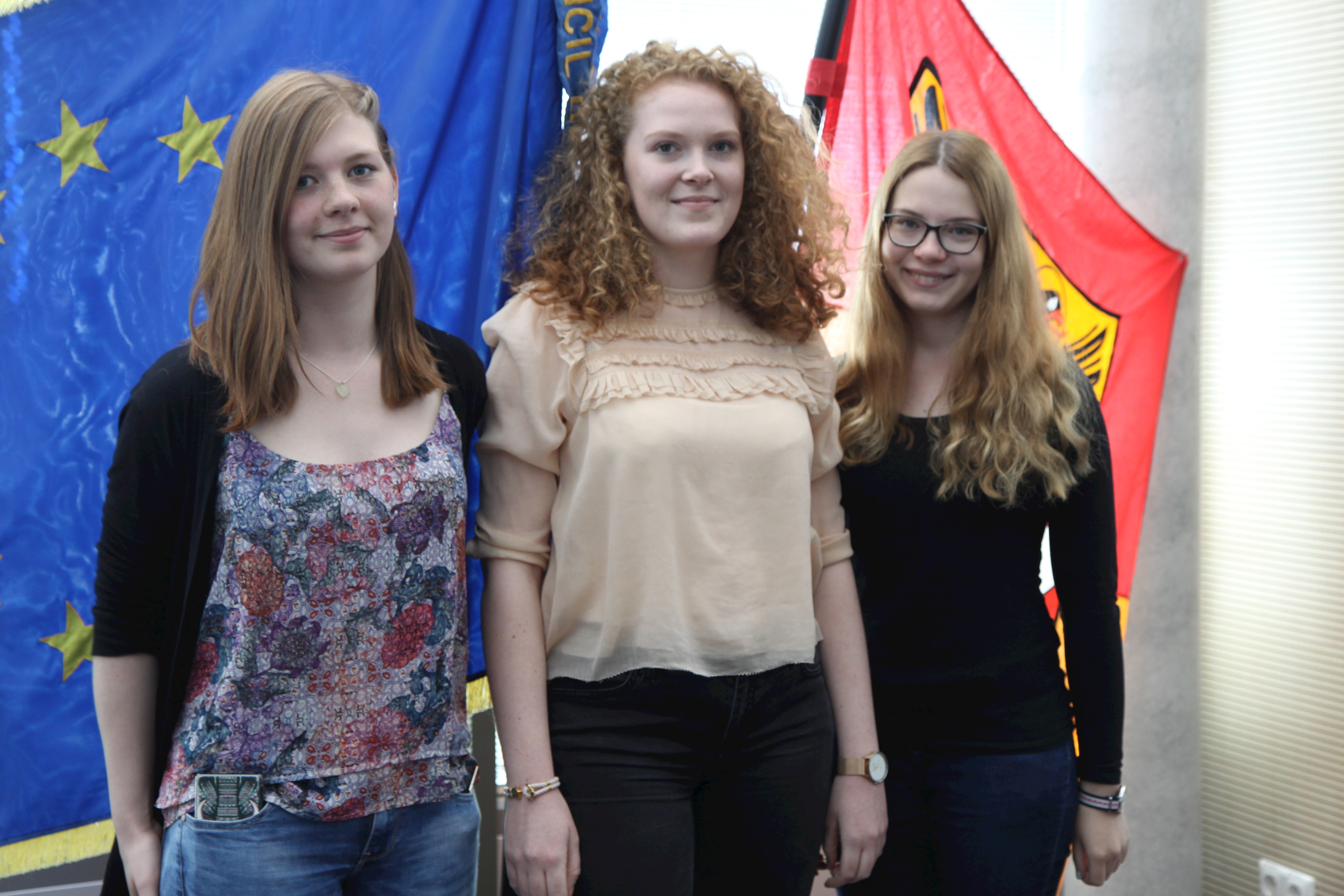 Im Bild vor der Europafahne im Sitzungssaal des Bezirks von links nach rechts: Anna Janson, Karen Dehner und Lena Kuchenbaur, die während ihrer Ausbildung beim Bezirk Auslandserfahrungen sammelten.
