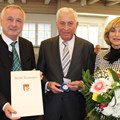 Bezirkstagspräsident Jürgen Reichert bei der Verleihung der Bezirksmedaille an Max Schuster, dessen Ehefrau Veronika sich mit freute über die hohe Auszeichnung (im Bild von links).