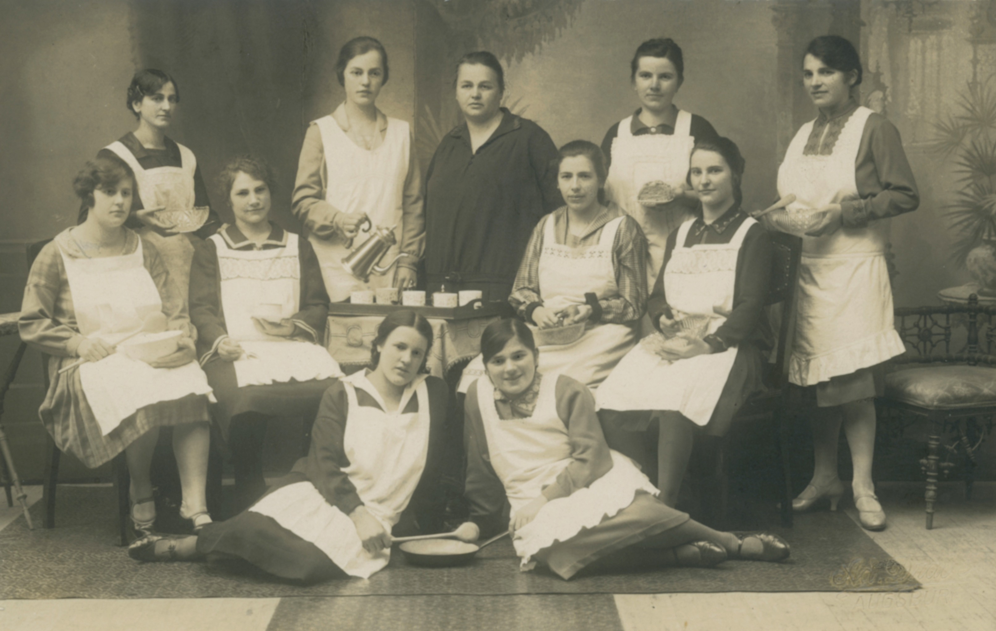 Teilnehmerinnen eines Kochkurses in Augsburg in blütenweiten Schürzen, 1923