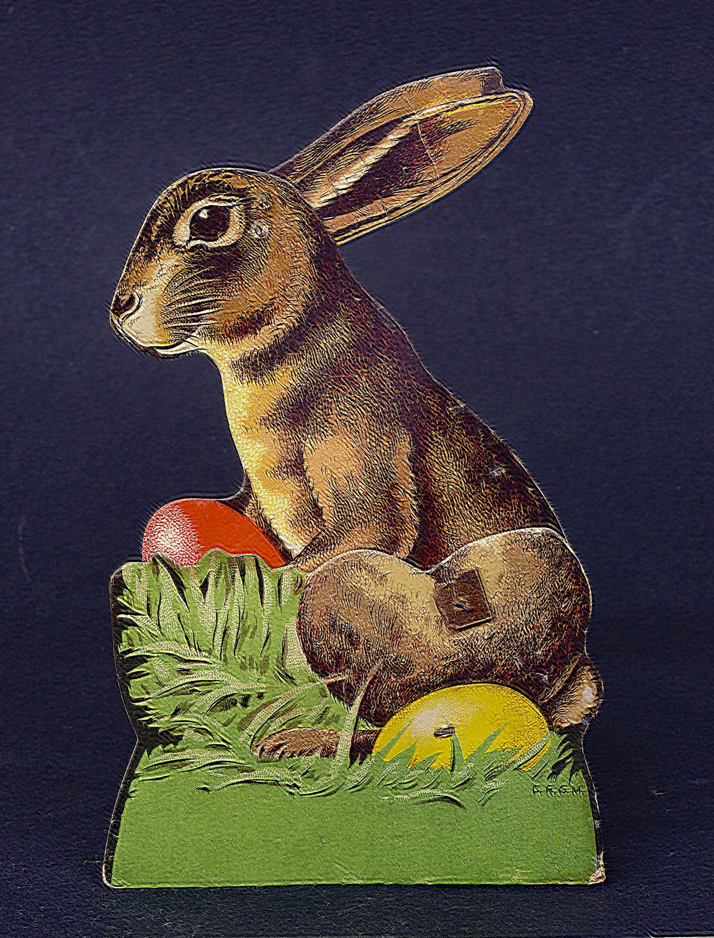 Die Osterhasen-Figur aus den 1920er Jahren ist aus Pappe und mit Scharnieren an den Ohren und den Beinen ausgestattet. Gern wurde der Osterhase in „Ruhestellung“ im Gras versteckt: das rote Ei ist dann nicht zu sehen, die Ohren angelegt.