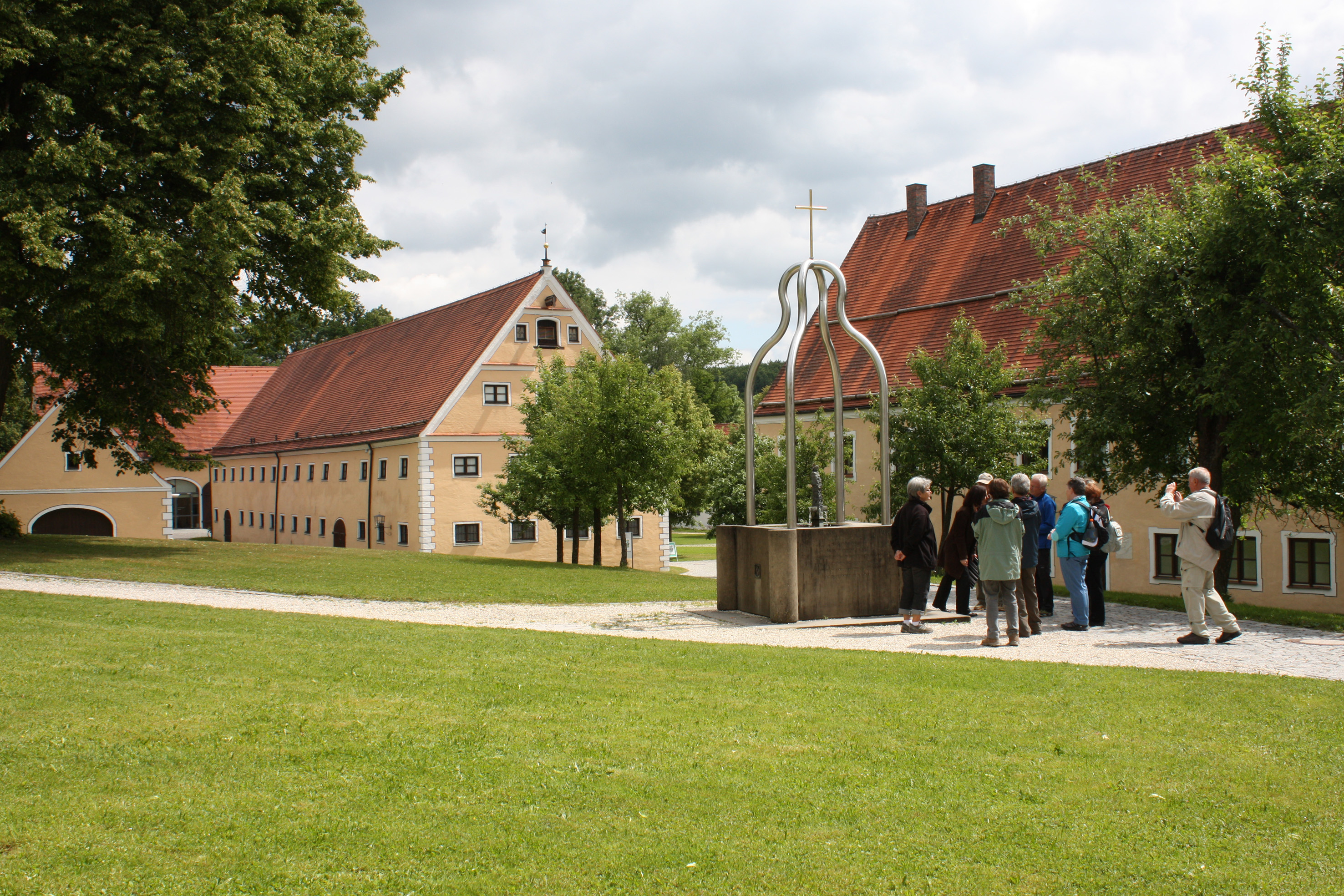 Brunnen im Klosterhof mit Besuchern und Gebäuden im Hintergrund